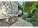 Outdoor stone kitchen and patio are surrounded by lush landscaping with mature trees and shrubbery at 3687 Canyon Ridge Ne Ct, Brookhaven, GA 30319