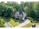 Aerial view of two-story brick home featuring a beautifully landscaped front yard, basketball court and driveway at 3705 Rolling Creek Dr, Buford, GA 30519