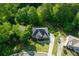 Aerial view showcases a beautifully landscaped property with mature trees, circular driveway and brick exterior at 3705 Rolling Creek Dr, Buford, GA 30519