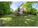 Secluded backyard with mature trees, a stone patio, and a well-maintained lawn at 3705 Rolling Creek Dr, Buford, GA 30519
