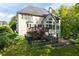 The backyard features lush greenery, a deck, stone patio and a black metal fence at 3705 Rolling Creek Dr, Buford, GA 30519