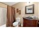 Cozy bathroom features a shower-tub combo, vanity with dark wood cabinets, and decorative framed art at 3705 Rolling Creek Dr, Buford, GA 30519
