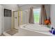 Relaxing bathroom featuring a corner tub, separate shower, and window with stained glass detail at 3705 Rolling Creek Dr, Buford, GA 30519