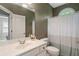 Full bathroom with vanity, decorative wall paper, toilet, tub and shower, and an arched window at 3705 Rolling Creek Dr, Buford, GA 30519