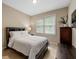 Cozy bedroom features neutral walls, a window with blinds, and classic dark wood furniture at 3705 Rolling Creek Dr, Buford, GA 30519