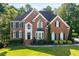 Charming two-story brick home featuring a beautifully landscaped front yard and classic architectural details at 3705 Rolling Creek Dr, Buford, GA 30519