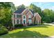 Charming two-story brick home featuring a beautifully landscaped front yard and classic architectural details at 3705 Rolling Creek Dr, Buford, GA 30519