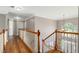 Second story hallway with wood floors, overlooking the foyer and front door at 3705 Rolling Creek Dr, Buford, GA 30519
