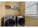 Efficient laundry room with modern front-load washer and dryer, plus organized shelving for storage at 3705 Rolling Creek Dr, Buford, GA 30519