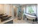 Elegant bathroom featuring a soaking tub, glass-enclosed shower, and marble countertops at 4271 Haywater Cv, Buford, GA 30519