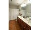 Bathroom with wood-style floors, double sink vanity and bath with shower curtain at 4271 Haywater Cv, Buford, GA 30519