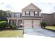 Inviting two-story home featuring a two-car garage and a cozy front porch, perfect for enjoying quiet moments at 4271 Haywater Cv, Buford, GA 30519