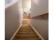 Carpeted staircase leading to the upper level, featuring neutral walls and wood railing at 4271 Haywater Cv, Buford, GA 30519