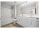 Well-lit bathroom featuring double sink vanity, large mirror and shower-tub combination with white finishes at 107 Cherry Glen Way, Euharlee, GA 30145