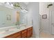 Bright bathroom showcasing double sinks, wood cabinets, a large mirror with accent lighting, and neutral wall decor at 224 Prominent Loop, Mcdonough, GA 30253