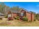 Charming brick home featuring manicured landscaping, a cozy bench, and lush greenery at 224 Prominent Loop, Mcdonough, GA 30253