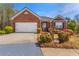 Charming brick home featuring a well-manicured front yard and attached two-car garage at 224 Prominent Loop, Mcdonough, GA 30253