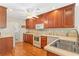 Bright kitchen with wood cabinets, white appliances, and hardwood floors at 224 Prominent Loop, Mcdonough, GA 30253