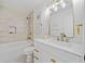 Bright bathroom features a white vanity with gold fixtures, a large mirror, and a shower-tub combination at 2442 Connally Dr, East Point, GA 30344