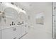 Bright bathroom with double vanity, round mirrors, and a walk-in shower featuring marble-style tile at 2442 Connally Dr, East Point, GA 30344