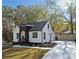 Charming renovated one-story home with white siding, black trim, landscaped yard, and a long concrete driveway at 2442 Connally Dr, East Point, GA 30344
