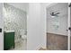 A well-lit hallway leads to a bathroom with modern wallpaper and a view into a bedroom at 2442 Connally Dr, East Point, GA 30344