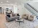 Open-concept living room boasts hardwood floors, a staircase and seamless flow to the dining and kitchen area at 2442 Connally Dr, East Point, GA 30344
