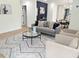 Bright living room with a gray couch, two accent chairs, and views into the home's kitchen and dining area at 2442 Connally Dr, East Point, GA 30344