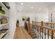 Upstairs hallway featuring hardwood floors, wood railing, and a decorative art piece at 5247 Flannery Chase Sw, Powder Springs, GA 30127