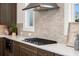 Modern kitchen featuring stainless steel range hood and cooktop, quartz countertops and stylish backsplash at 5247 Flannery Chase Sw, Powder Springs, GA 30127