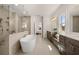 Spa-like bathroom with a freestanding tub, glass shower, double vanity, and neutral tile flooring at 5247 Flannery Chase Sw, Powder Springs, GA 30127