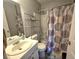 Functional bathroom with a patterned shower curtain, a vanity, and a well-lit mirror at 5602 Ardmore Ct, Sugar Hill, GA 30518