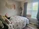 Comfortable bedroom with soft lighting, neutral walls, and a view of the outdoors through the window at 5602 Ardmore Ct, Sugar Hill, GA 30518