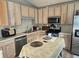 Functional kitchen with stainless steel appliances, light wood cabinets, and a central island at 5602 Ardmore Ct, Sugar Hill, GA 30518