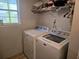 Efficient laundry room with a washer, a dryer, and a window for natural light, making chores a breeze at 5602 Ardmore Ct, Sugar Hill, GA 30518