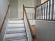 Bright staircase with wooden railings and white risers, leading to the upper level of the home at 5602 Ardmore Ct, Sugar Hill, GA 30518