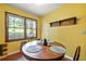 Eat-in kitchen features a rustic wood table, large window, and warm, sunny yellow walls at 671 Shannon Green Sw Cir, Mableton, GA 30126