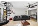 Living room featuring a spiral staircase, black sectional, tile floor, and modern fan at 951 Glenwood Se Ave # 1805, Atlanta, GA 30316