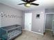 Charming Bedroom with gray crib and whimsical wall decals, illuminated by a modern ceiling fan at 1185 Charter Club Dr, Lawrenceville, GA 30043