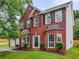 Charming two-story red brick home with a manicured lawn and a two-car garage at 1185 Charter Club Dr, Lawrenceville, GA 30043