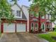Charming two-story red brick home with a manicured lawn and a two-car garage at 1185 Charter Club Dr, Lawrenceville, GA 30043