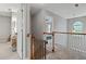 Upstairs hallway with safety gate, railing and natural light from a window, creating a welcoming space at 1185 Charter Club Dr, Lawrenceville, GA 30043