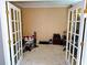 Home office space with white French doors and neutral carpeting at 1185 Charter Club Dr, Lawrenceville, GA 30043