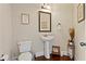 A compact bathroom featuring a white sink and toilet, plus decorative artwork at 1307 Clarecastle Ln, Buford, GA 30519