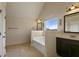 Bathroom view showing a soaking tub, vanity with dark cabinets, and natural light at 1307 Clarecastle Ln, Buford, GA 30519