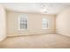 Spacious bedroom with two windows, carpet flooring, and ceiling fan at 2279 Hawks Bluff Trl, Lawrenceville, GA 30044
