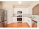 Modern kitchen with stainless steel appliances, white cabinets, and wood flooring at 2279 Hawks Bluff Trl, Lawrenceville, GA 30044
