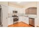 Modern kitchen with stainless steel appliances, white cabinets, and wood flooring at 2279 Hawks Bluff Trl, Lawrenceville, GA 30044
