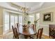 Elegant dining room with large windows, wood floors and view of the front foyer at 352 Hickory Haven Ter, Suwanee, GA 30024
