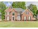 Two-story brick home with a well-manicured lawn and mature trees at 352 Hickory Haven Ter, Suwanee, GA 30024